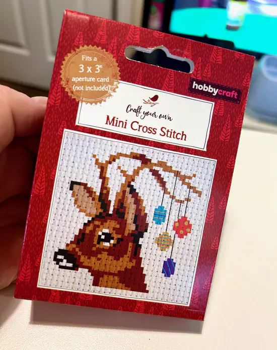 A photograph of a Hobbycraft cross stitch kit. The final image is of a reindeer with Christmas ornaments hanging from their antlers.