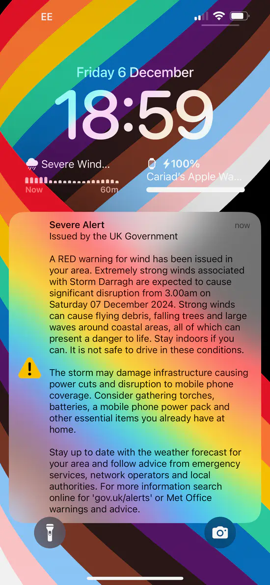 A screenshot of an iPhone showing a severe alert issued by the UK Government: A RED warning for wind has been issued in your area. Extremely strong winds associated with Storm Darragh are expected to cause significant disruption from 3.00am on Saturday 07 December 2024. Strong winds can cause flying debris, falling trees and large waves around coastal areas, all of which can present a danger to life. Stay indoors if you can. It is not safe to drive in these conditions. The storm may damage infrastructure causing power cuts and disruption to mobile phone coverage. Consider gathering torches, batteries, a mobile phone power pack and other essential items you already have at home. Stay up to date with the weather forecast for your area and follow advice from emergency services, network operators and local authorities. For more information search online for 'gov.uk/alerts' or Met Office warnings and advice.