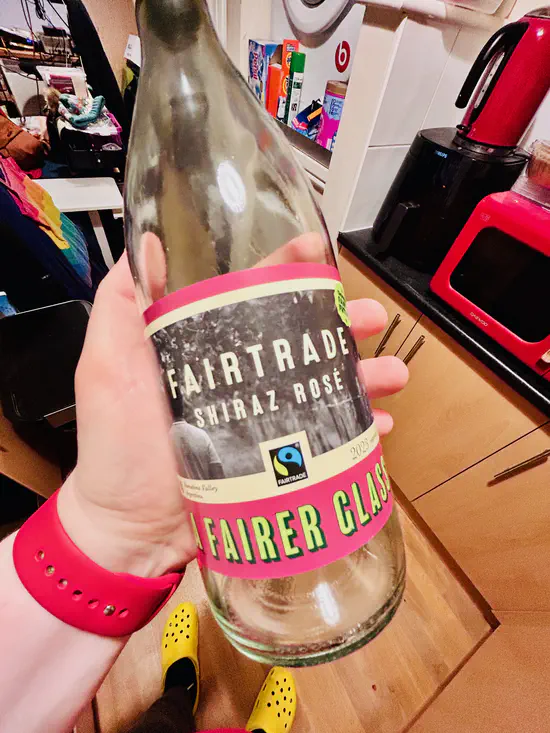 A photograph of an empty bottle of Co-op Fairtrade Shiraz Rosé wine.